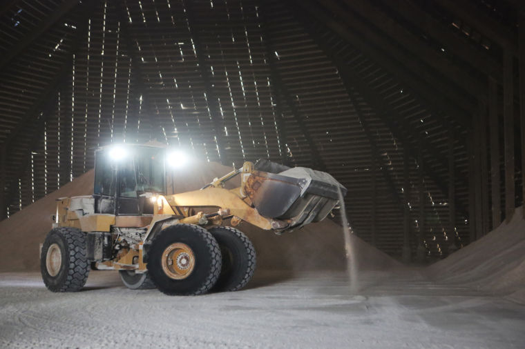 Front loader moving salt in storage facility